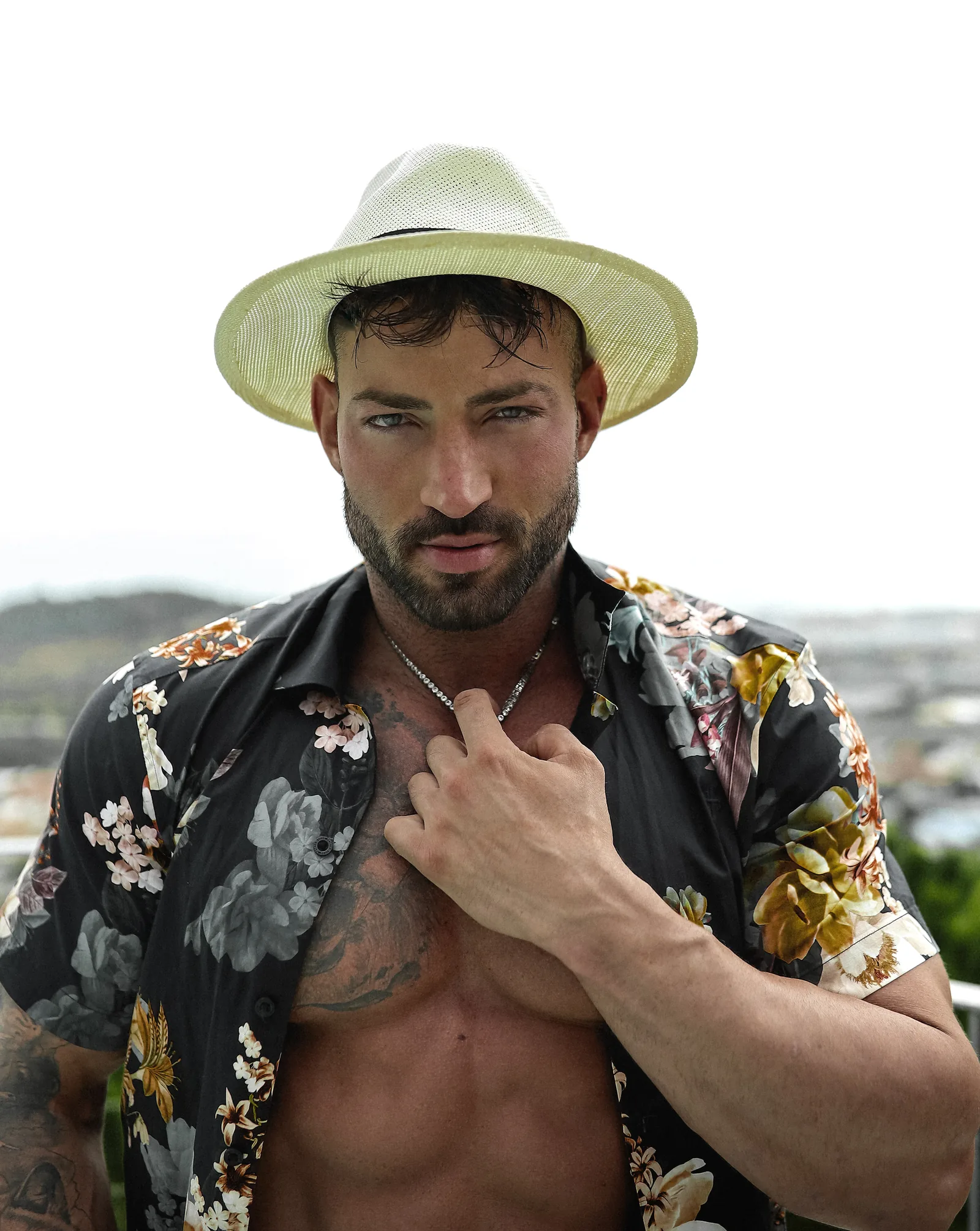 Maximo Garcia in a Panama hat and floral shirt, looking straight at the camera