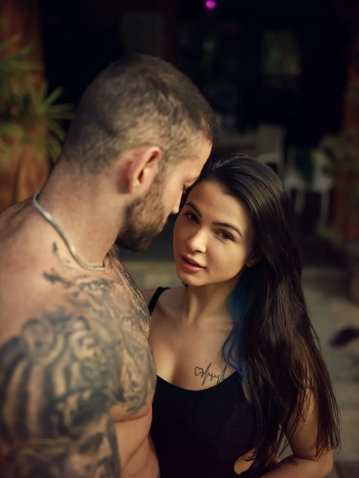 Maximo Garcia leaning in close to a dark-haired woman in a black top during a quiet conversation